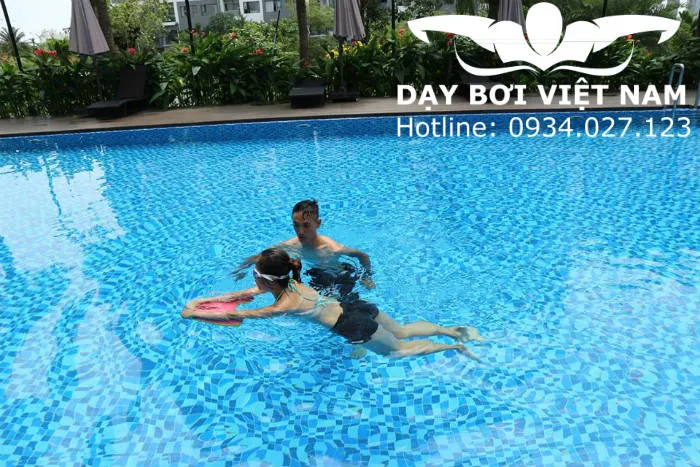 Huấn luyện viên đang hướng dẫn kỹ thuật bơi chuyên nghiệp tại hồ bơi khách sạn Victory