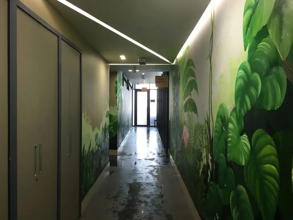 Lối hành lang dẫn vào khu vực phụ trợ của bể bơi bốn mùa Sunrise Club được trang trí sinh động